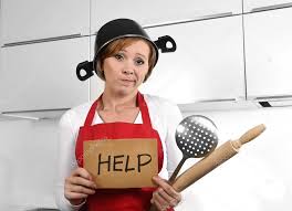 Woman in kitchen holding a sign that says help